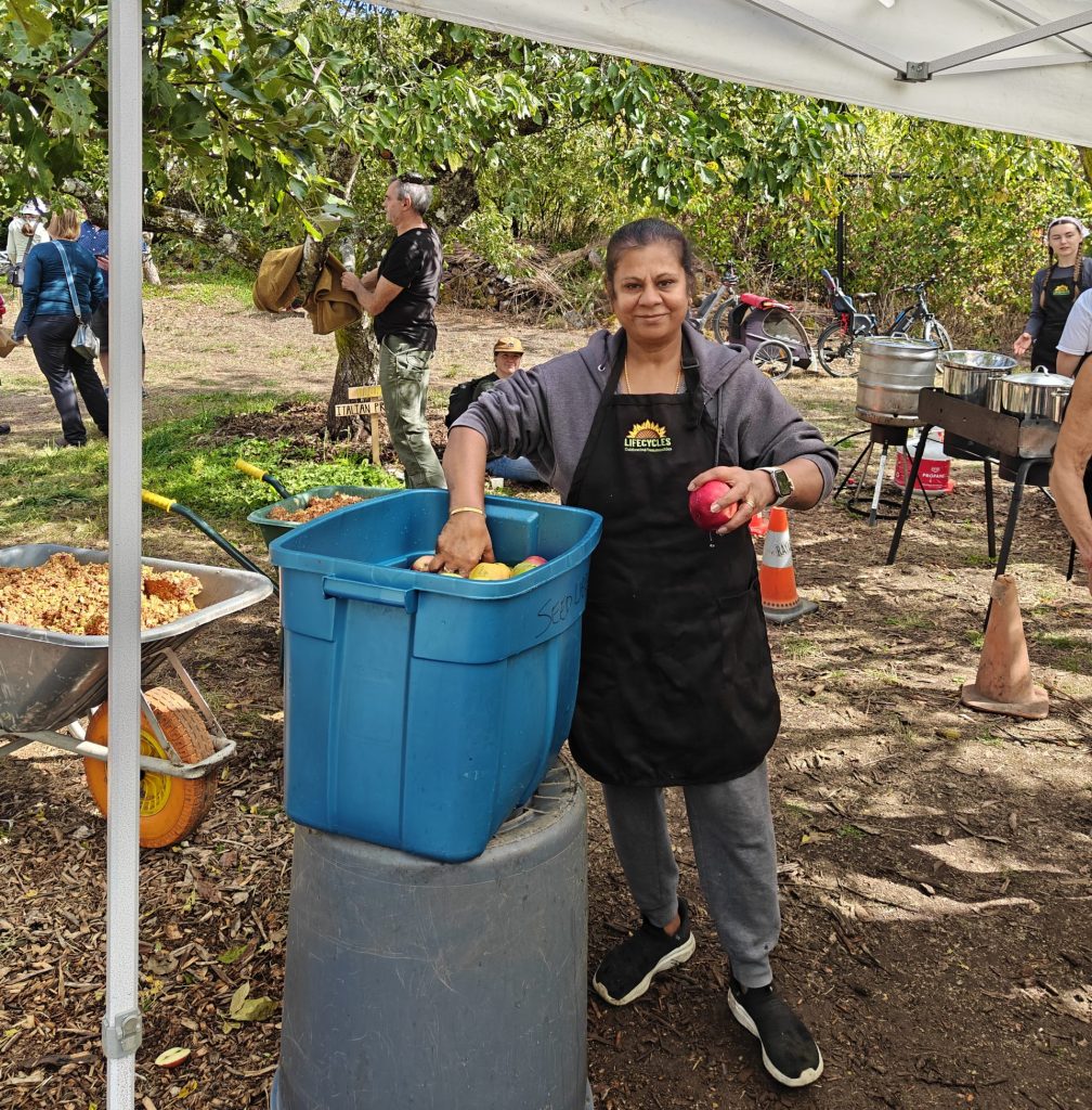 A LifeCycles volunteer washing apples at the apple pressing station.